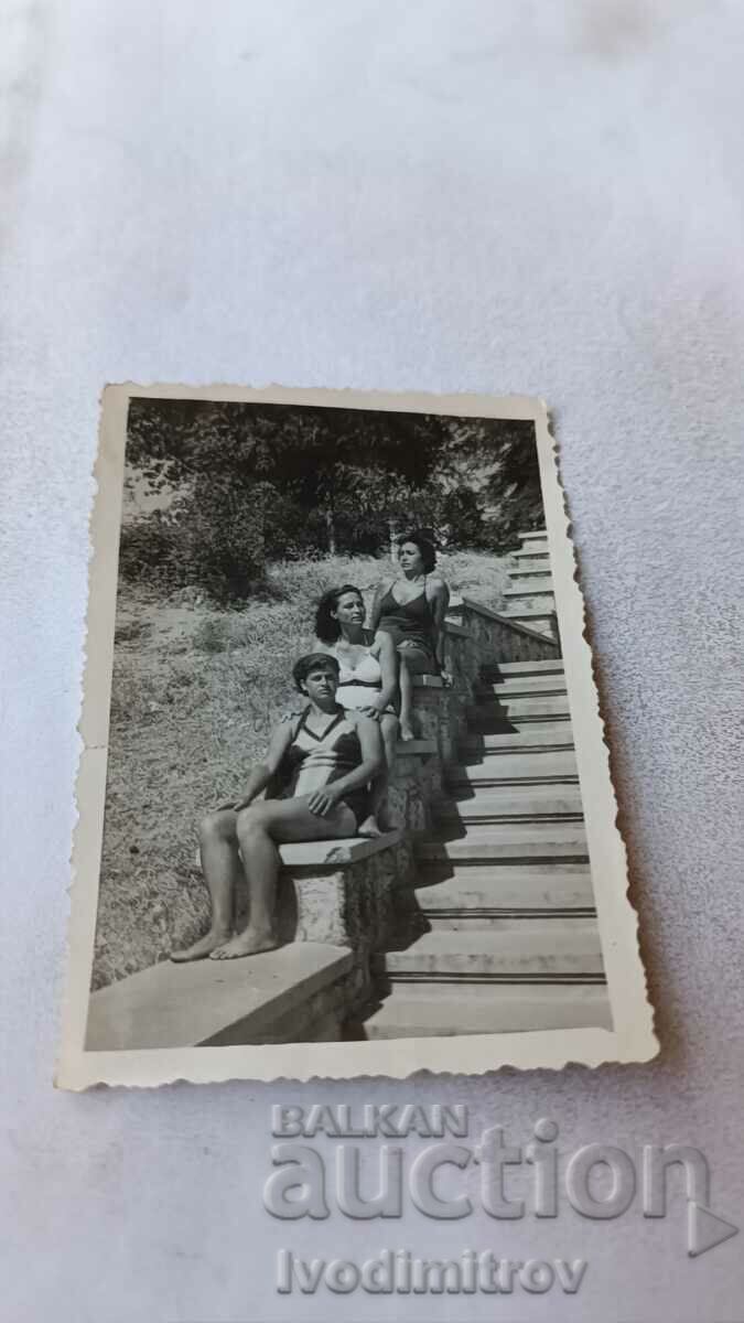 Φωτογραφία Τρεις νεαρές γυναίκες που κάθονται στα σκαλοπάτια