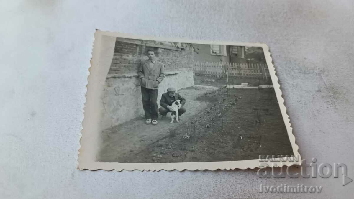 Φωτογραφία Δύο άντρες και ένα μικρό σκυλί