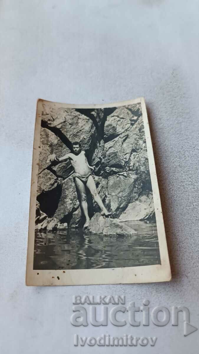 Снимка Млад мъж с ретро бански на скали покрай морето