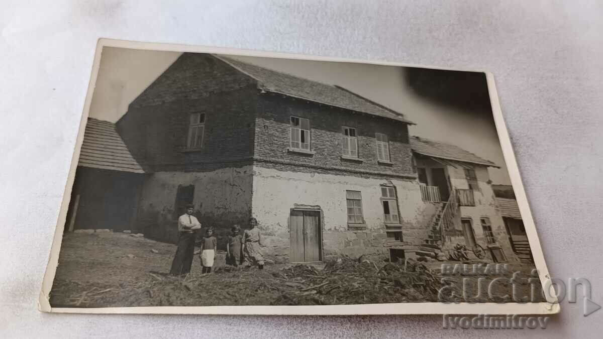 Φωτογραφία Άνδρας, γυναίκα και δύο παιδιά μπροστά από ένα εξοχικό σπίτι