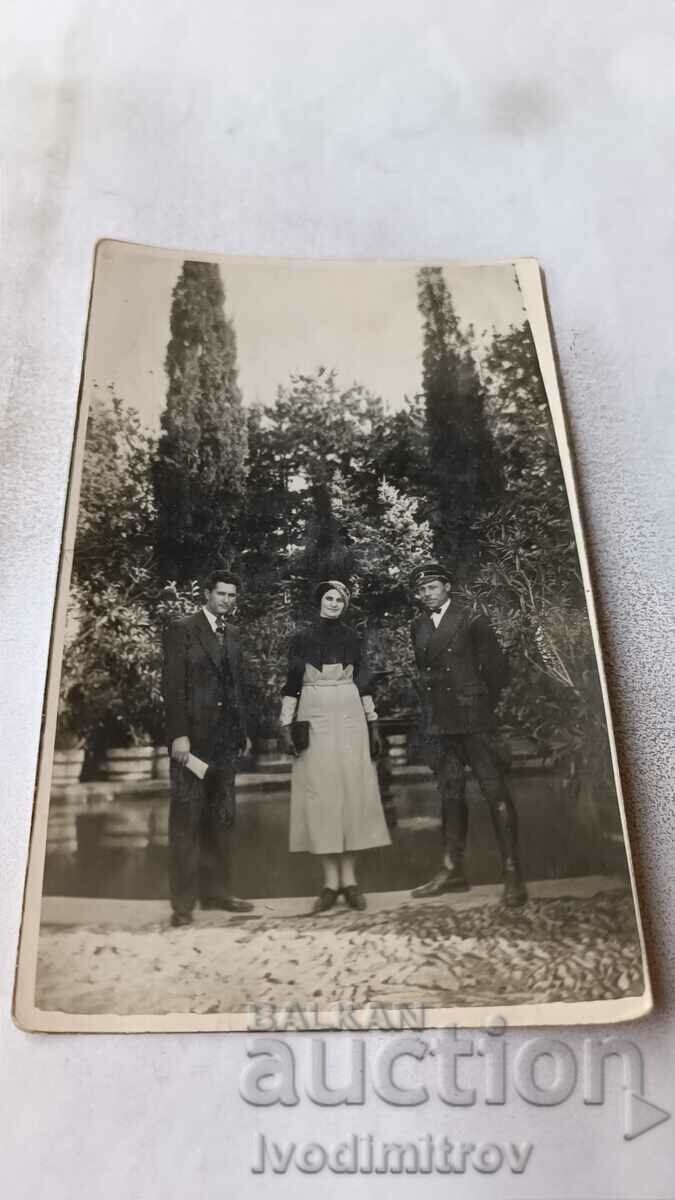 Photo Pleven Two men and a young woman in front of a pond in the park
