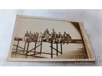 Снимка Мъже жени и деца седнали на пристана