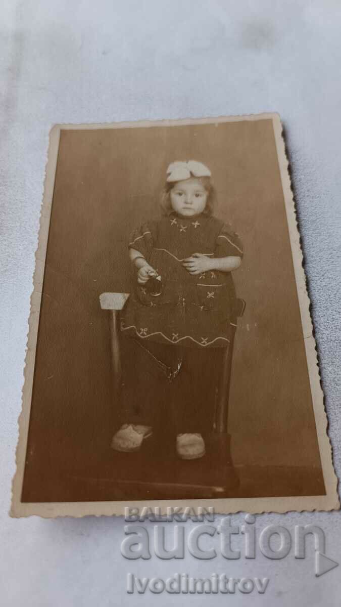 Φωτογραφία Ένα μικρό κορίτσι που κάθεται σε μια καρέκλα