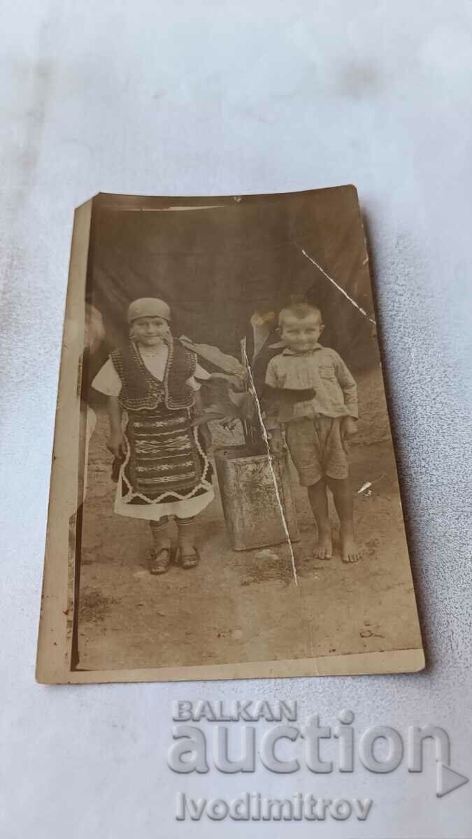 Foto O fată tânără în haine tradiționale și un băiețel