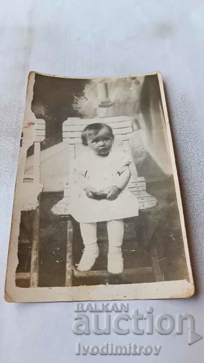 Photo Little girl on a wooden chair