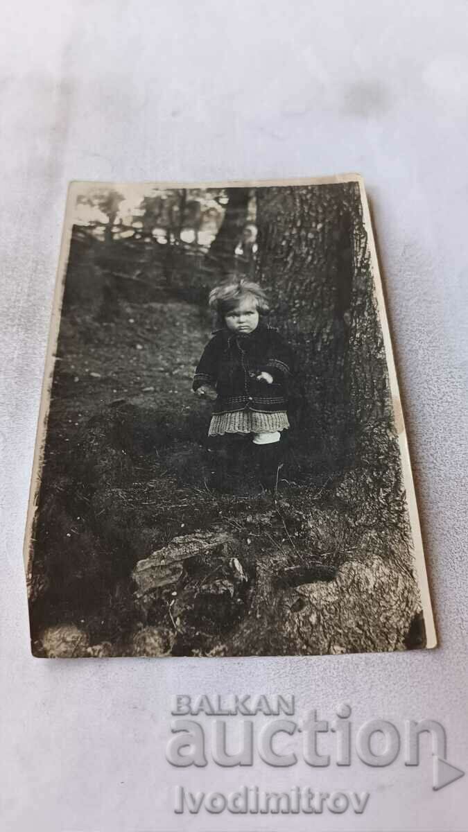 Photo Little girl next to a tree