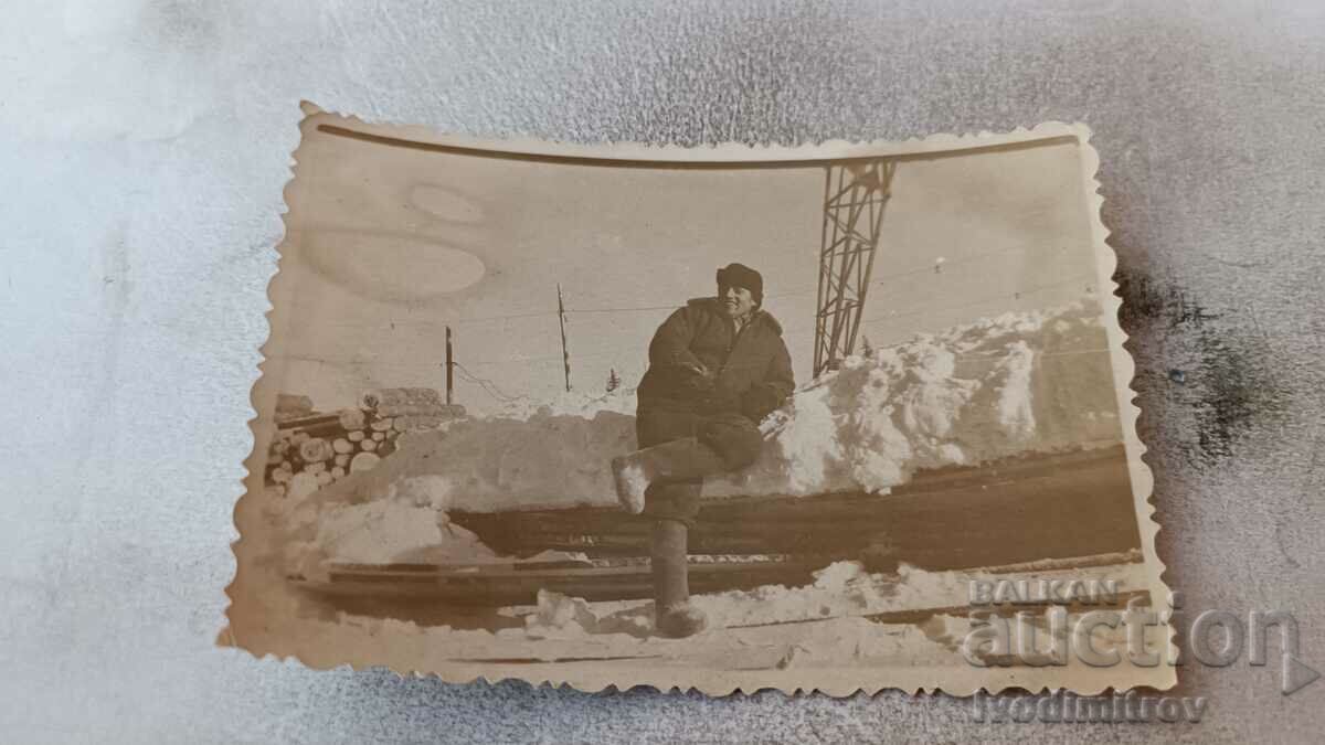 Снимка Коми Мъж до дървени трупи през зимата