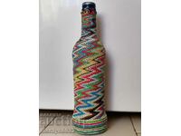 Old glass bottle with colorful braid bottle, glass