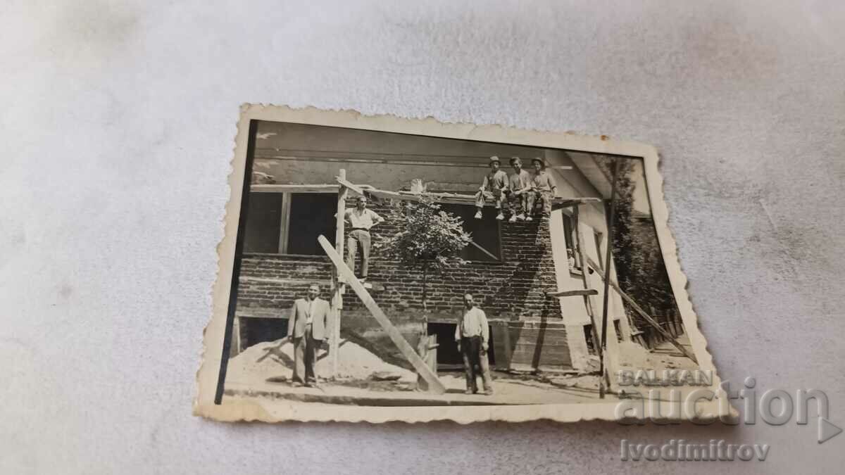 Photo Men in front of a newly built house