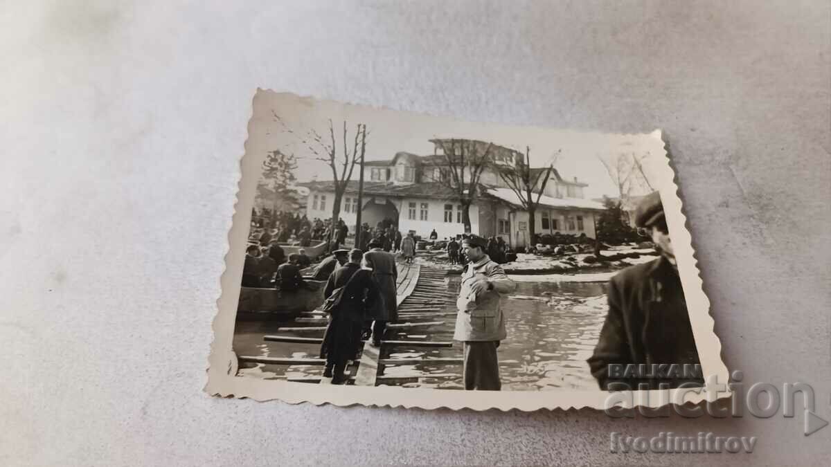 Photo Officers and men on a wooden pontoon bridge on a river