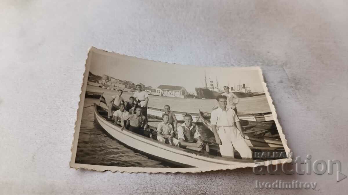 Photo Young men in a wooden boat on the pier