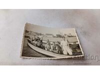 Photo Young men in a wooden boat on the pier