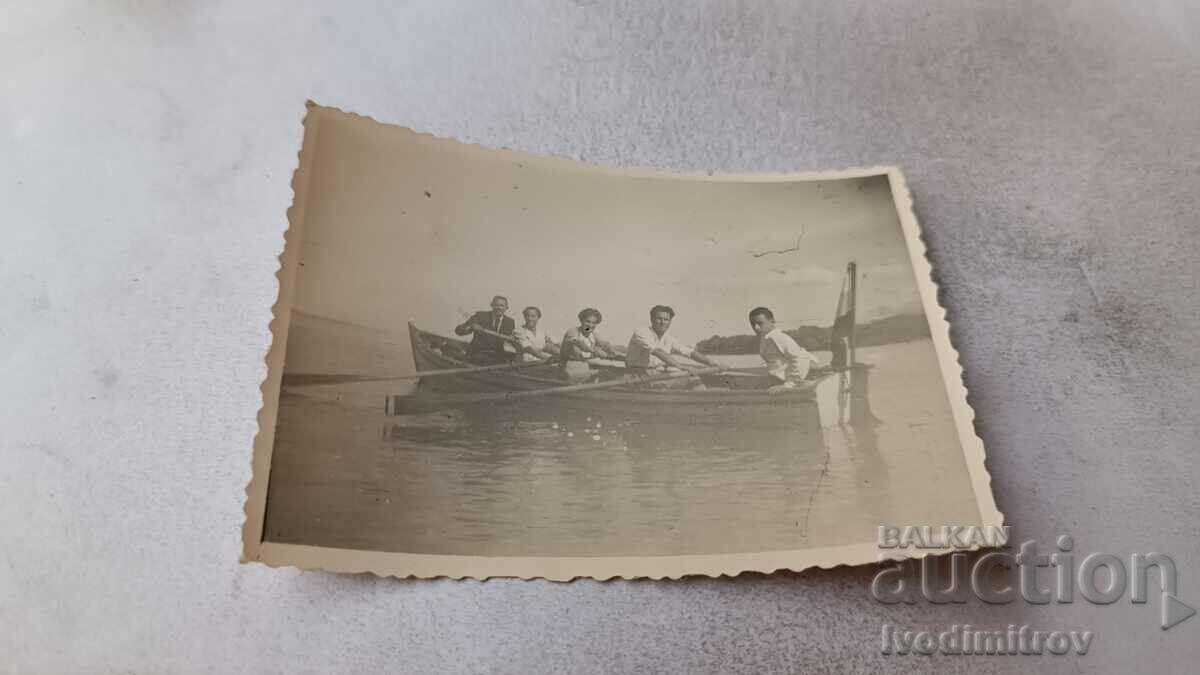 Photo Young men with a rowing boat in the sea