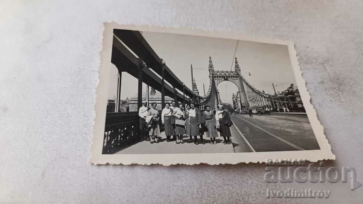 Photo Men and women in military uniforms on a bridge over a river