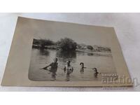 Φωτογραφία Τέσσερις νεαροί άνδρες που κάνουν μπάνιο στο ποτάμι