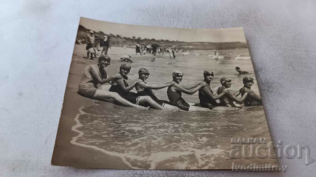 Photo Young girls sitting on a train on the beach