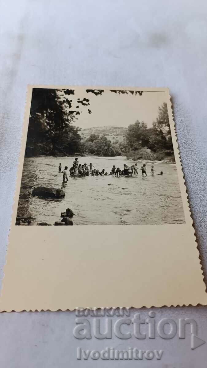 Снимка Жена и деца къпещи се в реката