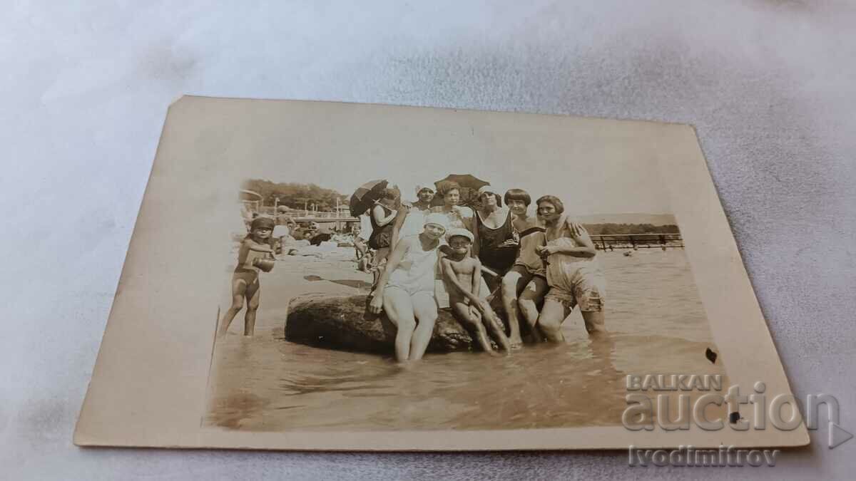 Снимка Млади момичета върху камък на брега на морето
