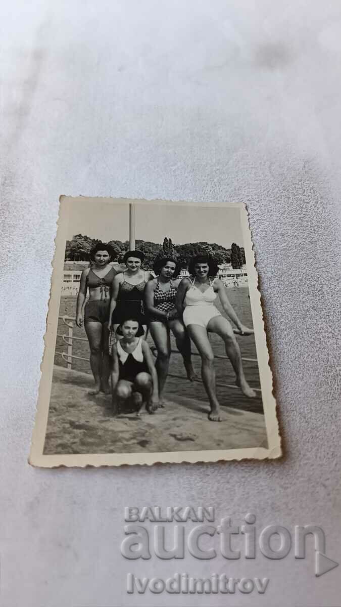 Imagine Cinci fete tinere în costume de baie pe debarcader