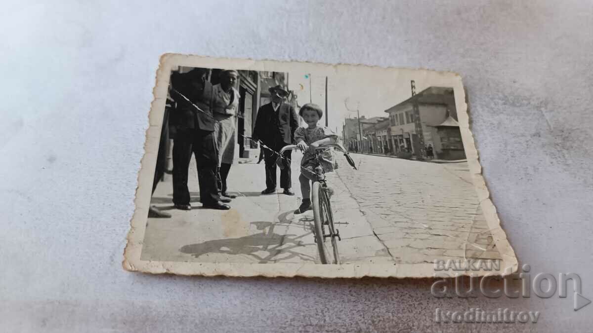 Fotografie Sofia Trei bărbați și o fată cu o bicicletă de epocă pe trotuar
