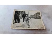 Φωτογραφία Σοφία Τρεις άντρες και ένα κορίτσι με ένα vintage ποδήλατο στο πεζοδρόμιο