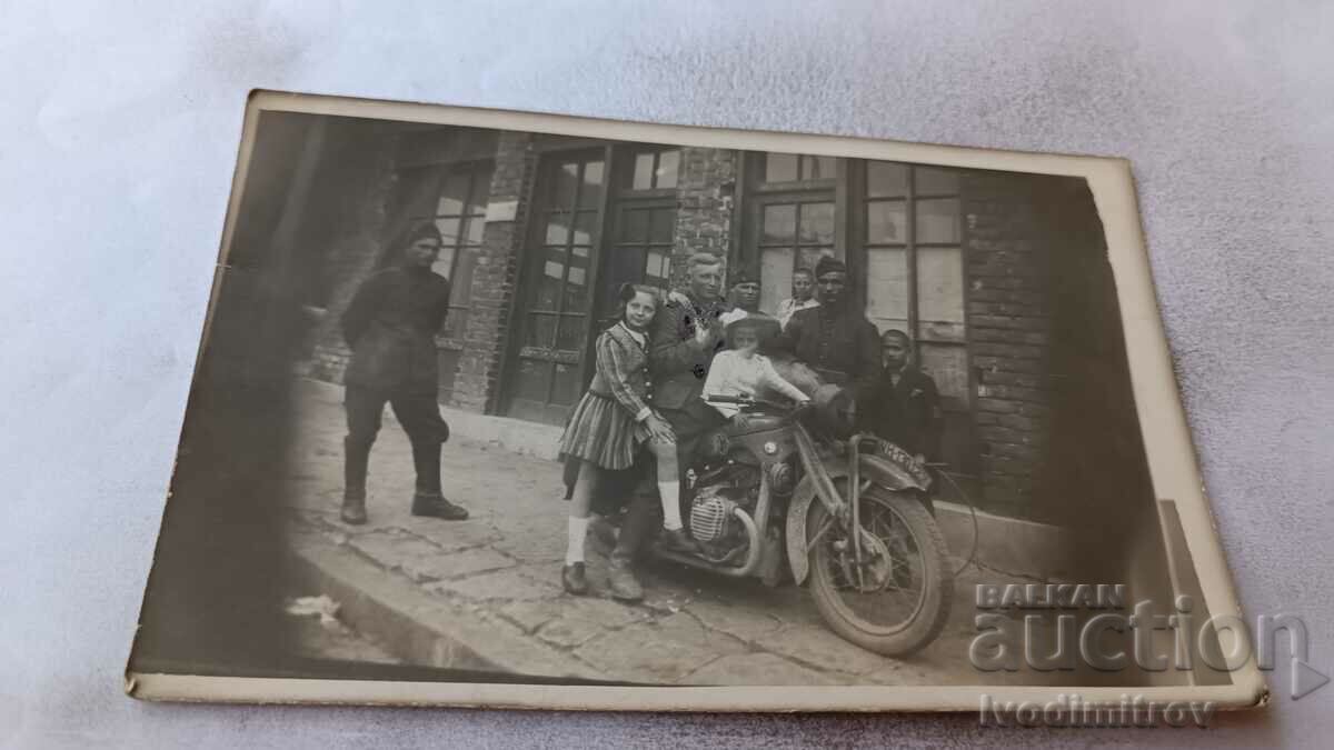 Foto Doi ofițeri și copii pe o motocicletă de epocă cu numărul de înmatriculare WH-13012
