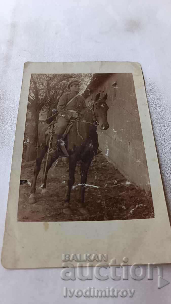 Αξιωματικός φωτογραφιών με τουφέκι και σπαθί σε μαύρο άλογο