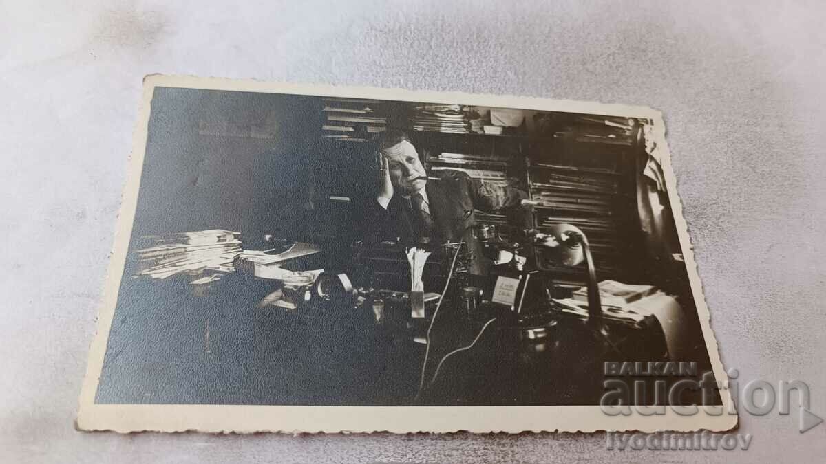 Φωτογραφία Ένας άντρας με ένα τσιγάρο στο γραφείο του
