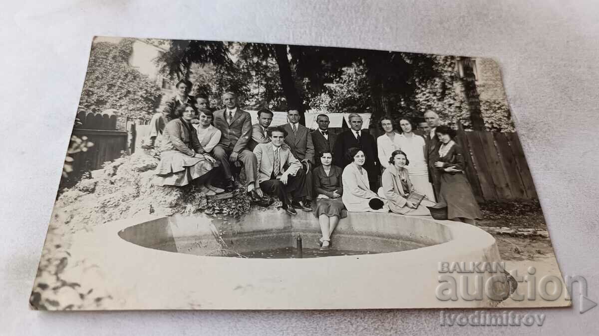 Photo Men and women by a fountain