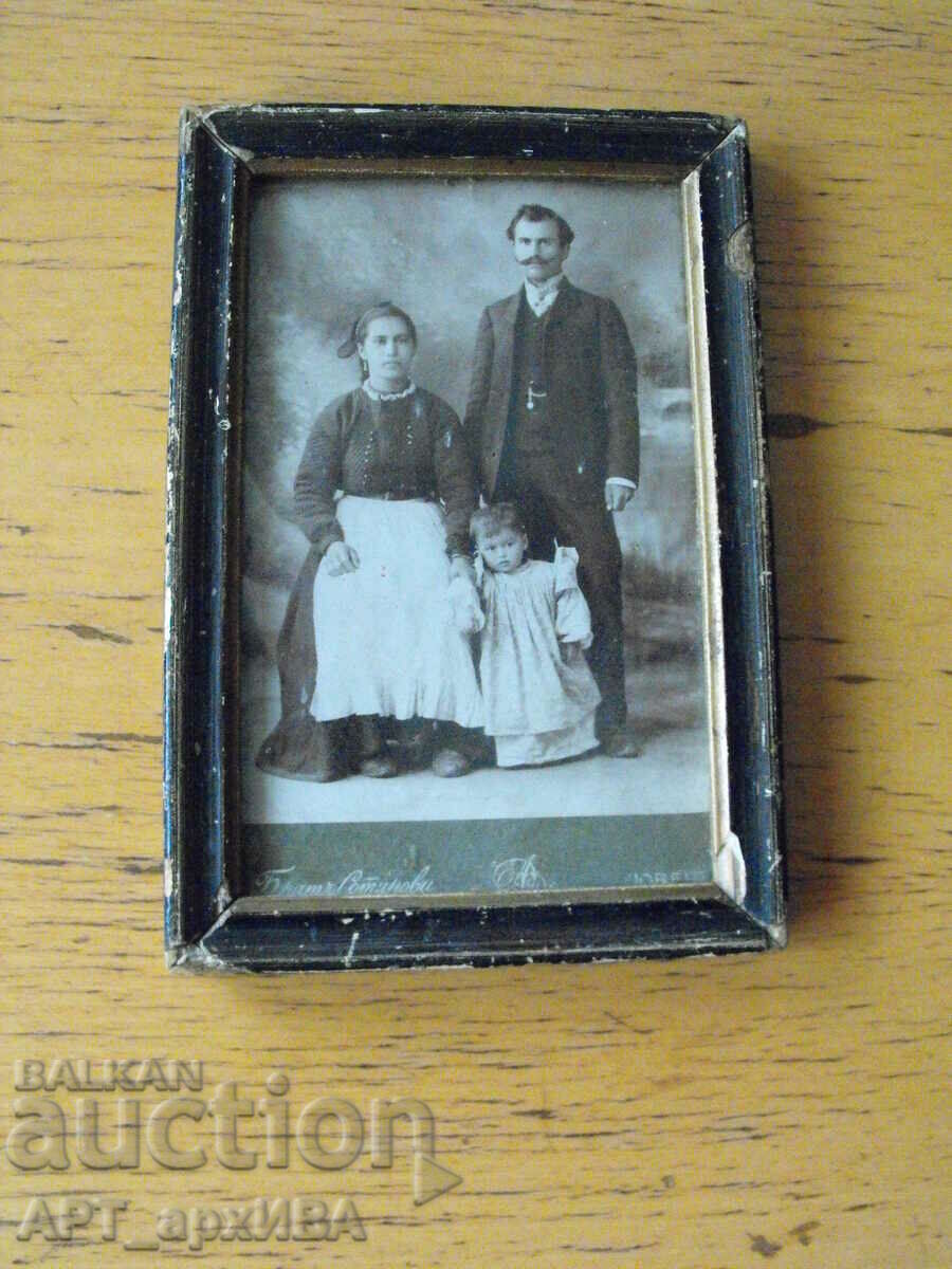Fotografie de familie, într-o ramă de lemn cu sticlă.