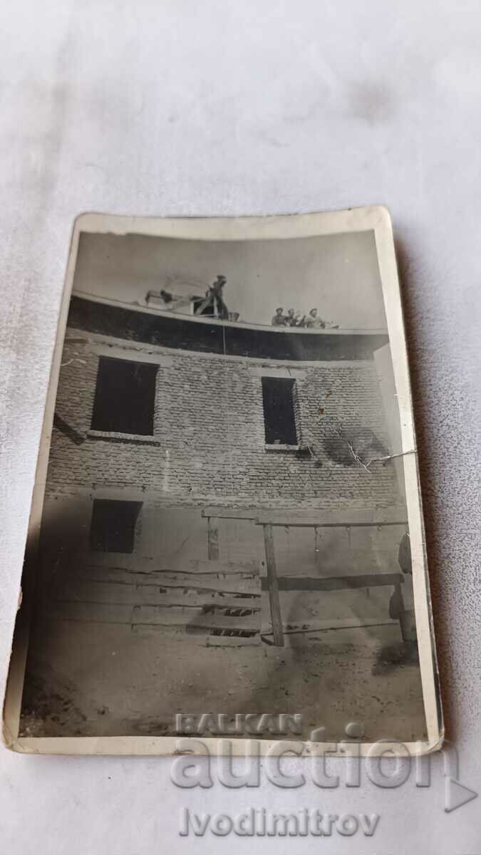 Foto Bărbați pe acoperișul unei clădiri nou construite