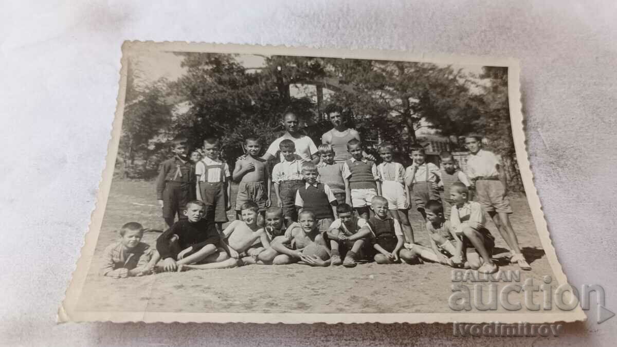 Foto Doi bărbați și copii cu o minge de fotbal pe teren