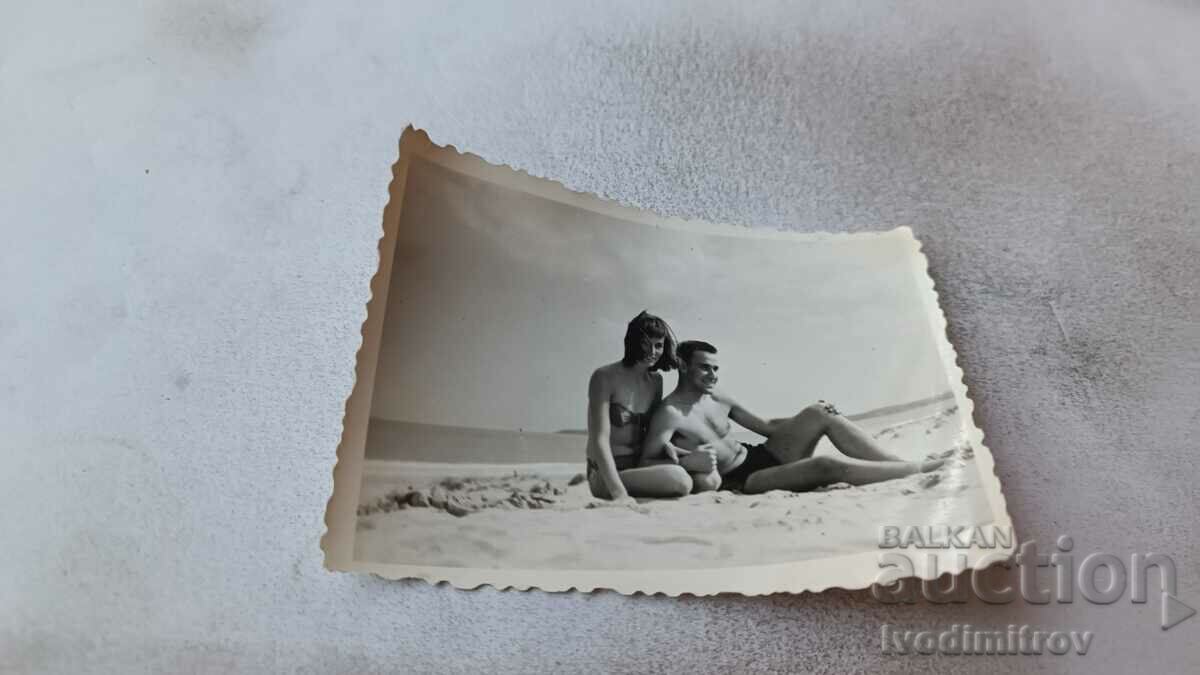 Photo A young man and a girl on the beach