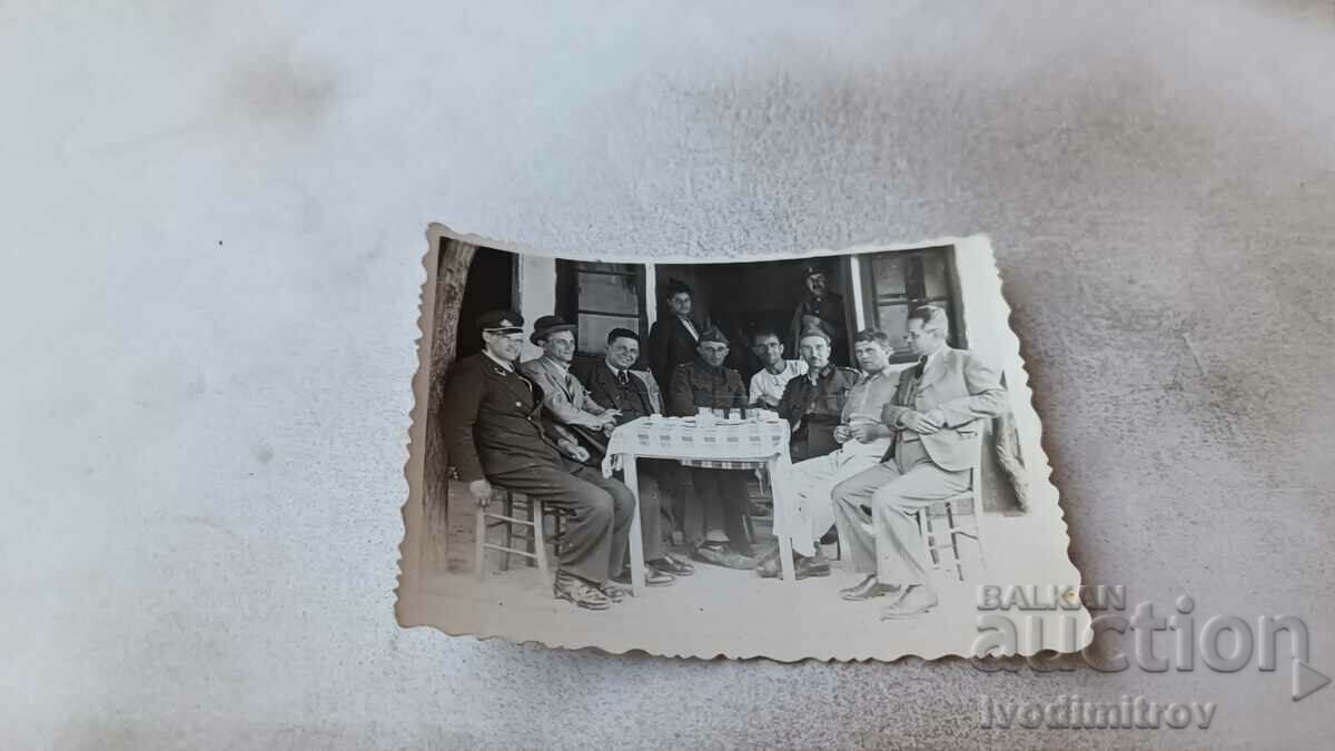 Φωτογραφικοί αξιωματικοί και άνδρες που πίνουν ένα ποτό σε ένα τραπέζι