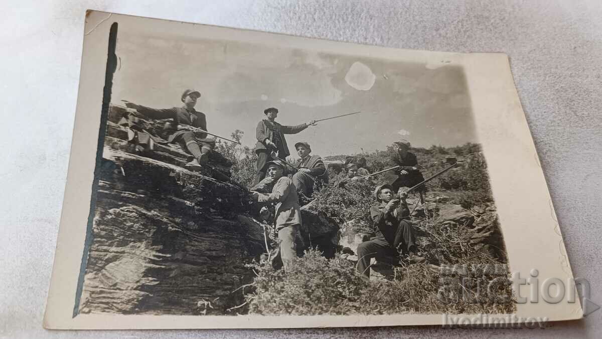 Foto Vânători stând pe o stâncă