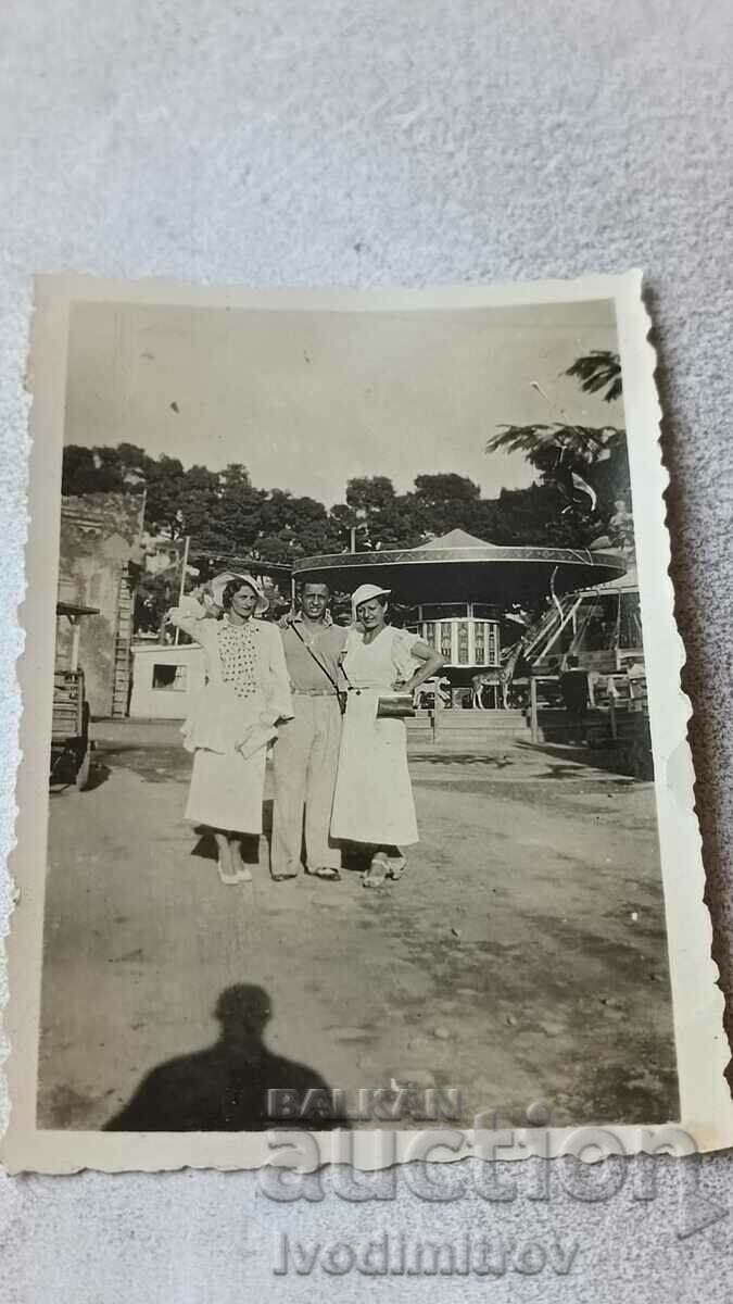 Снимка Солунъ Мъж и две млади жени с бели рокли в лунапарк