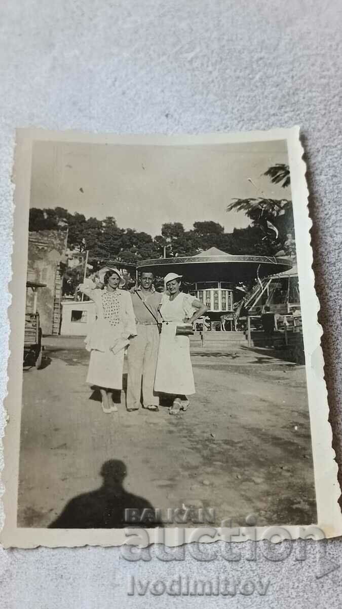 Photo Thessaloniki A man and two young women in white dresses in an amusement park