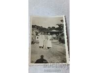 Photo Thessaloniki A man and two young women in white dresses in an amusement park