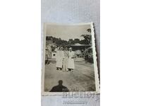 Photo Thessaloniki A man and two young women in white dresses in an amusement park