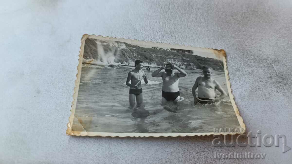Foto Trei bărbați pe plajă
