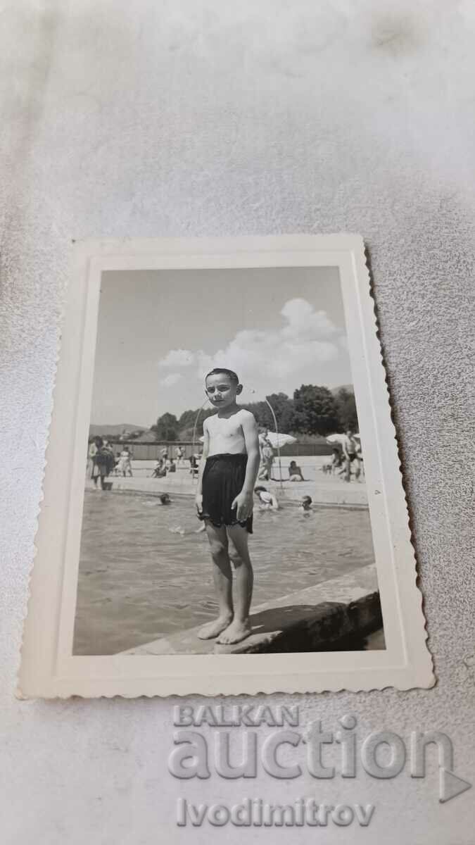 Photo A boy in a vintage swimsuit by a swimming pool