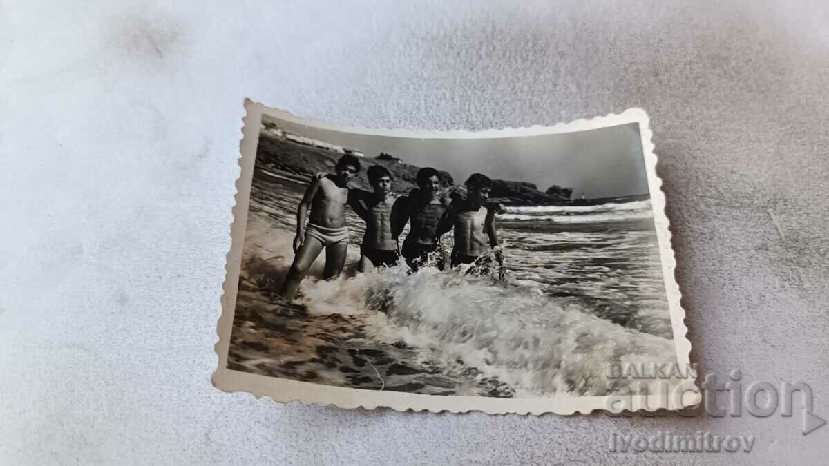 Foto Patru tineri pe plajă