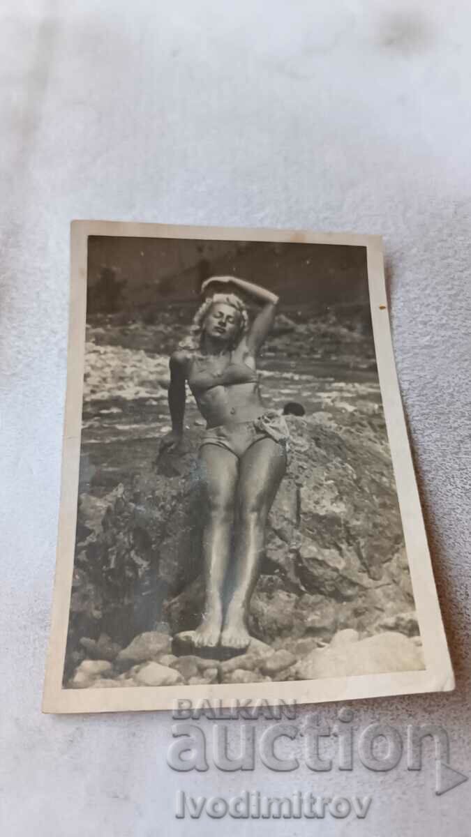 Photo Young girl in a swimsuit on the rocks