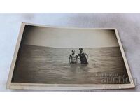Снимка Младеж и младо момиче с ретро бански костюм в морето