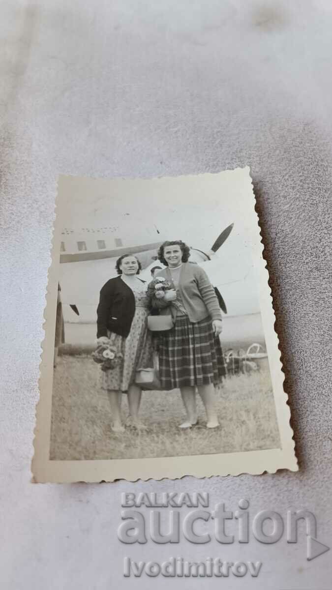 Photo Two women in front of a royal plane