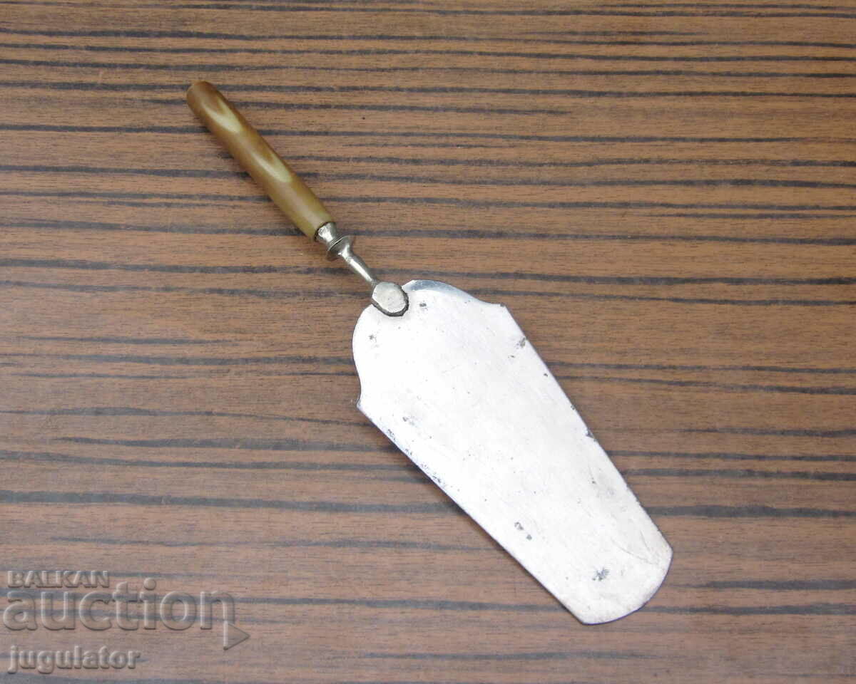 Δημοπρασία μια παλιά σπάτουλα σερβιρίσματος με στολίδια και λαβή από βακελίτη Δημοπρασία μια παλιά σπάτουλα σερβιρίσματος με στολίδια και λαβή από βακελίτη