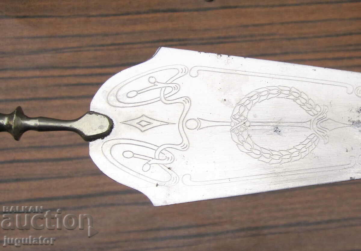 Παράδοση μια παλιά σπάτουλα σερβιρίσματος με στολίδια και λαβή από βακελίτη Παράδοση μια παλιά σπάτουλα σερβιρίσματος με στολίδια και λαβή από βακελίτη