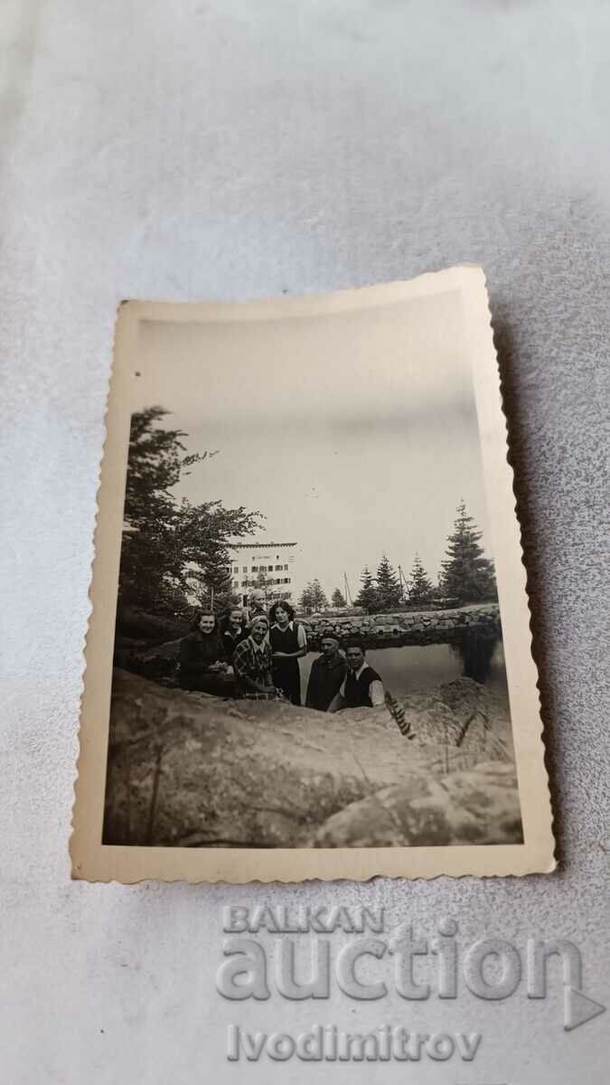 Φωτογραφία Άνδρες και γυναίκες μπροστά από μια καλύβα στο βουνό