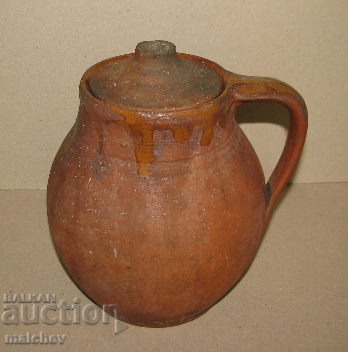 Old clay pot, jar with handle and lid, preserved glued