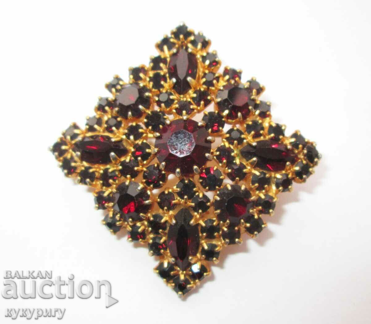 A beautiful old lady's gold-plated brooch with garnet stones